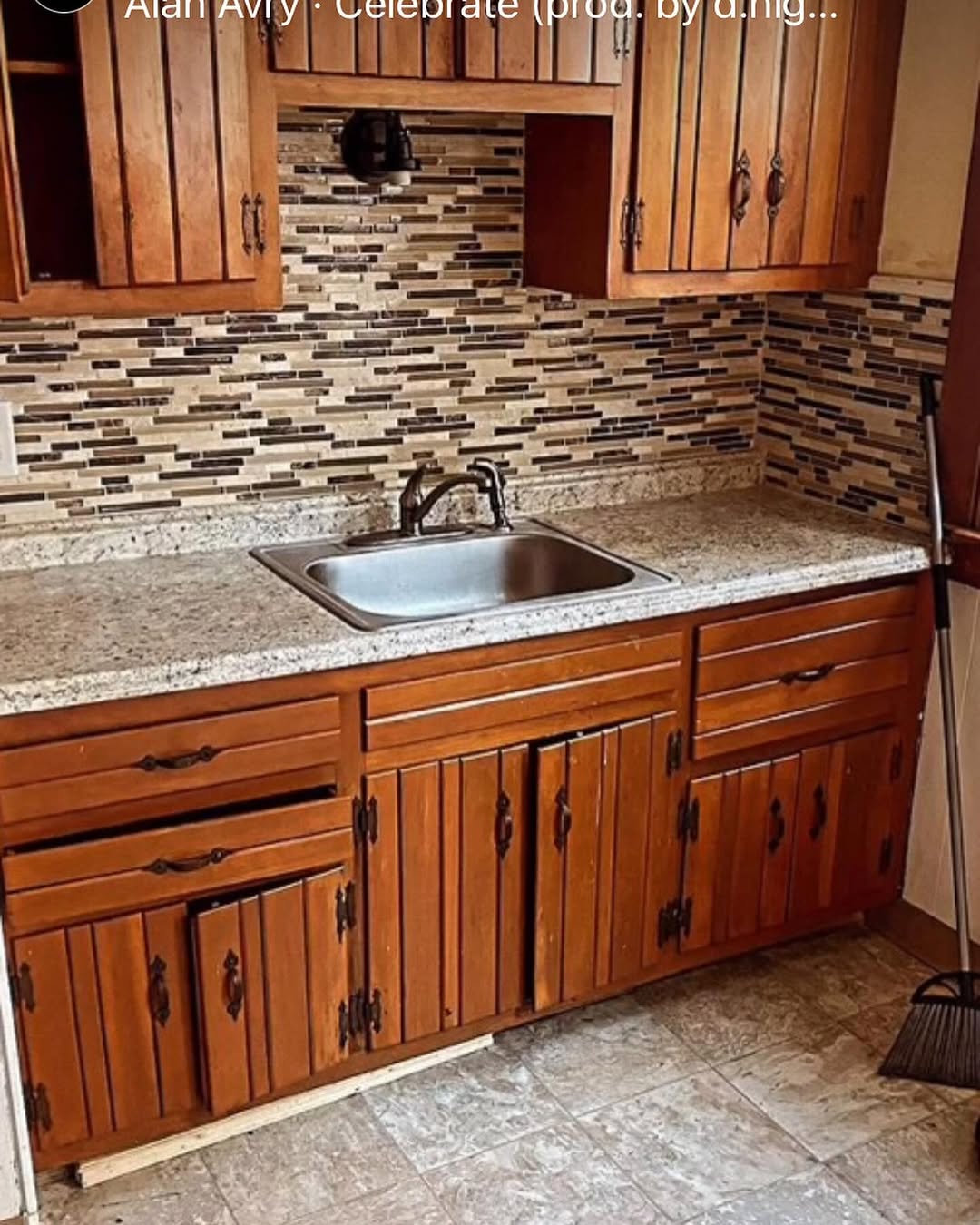Kitchen before renovation — dark wood cabinets with mosaic backsplash