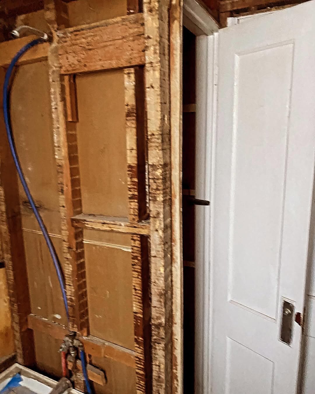 Wall opened with plumbing rough-in visible